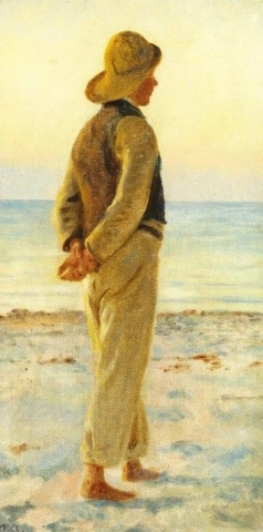 Ein Junge steht am Strand und blickt auf das Meer