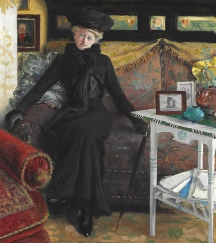 De actrice Oda Nielsen, gekleed in het zwart, zit in de woonkamer van de kunstenaar in Sofievej