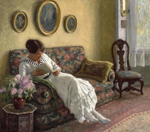 Musse, la esposa del artista, lee en el sofá de su casa en Sofievej en Hellerup