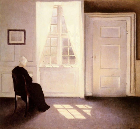 En dame som leser i et interiør