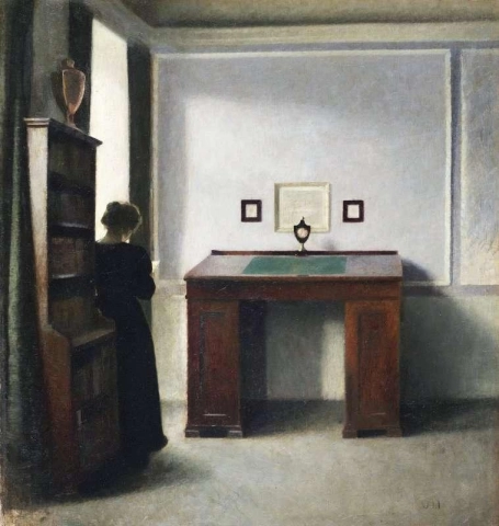 Et skrivebord og en ung kvinne i et interiør 1900