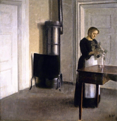 Interiør med kvinne som setter kvister i et glass Strandgade 30 1900