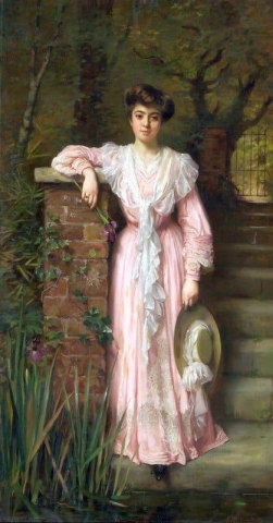 Ein Porträt einer Dame in einem Garten, die ein rosa Kleid trägt und eine Iris hält