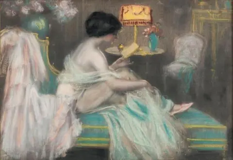 ソファで手紙を読む女性